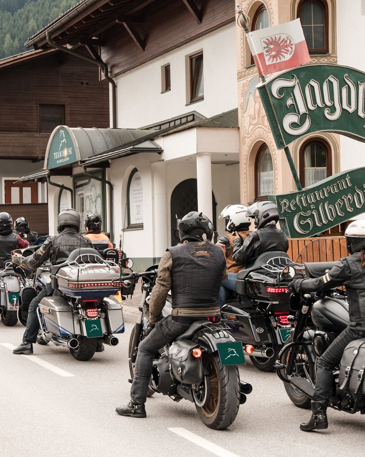 Außergewöhnliche Veranstaltungen im Jagdhof Gruppe von Motorradfahrern vor einem traditionellen Gasthaus in den Bergen