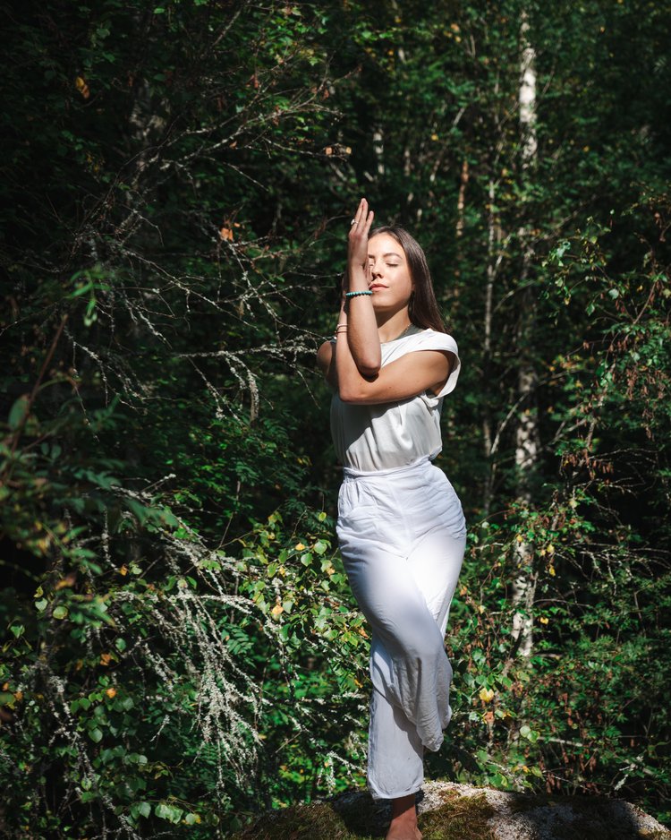 Außergewöhnliche Veranstaltungen im Jagdhof Frau macht Yoga-Pose in weißer Kleidung in grünem Wald