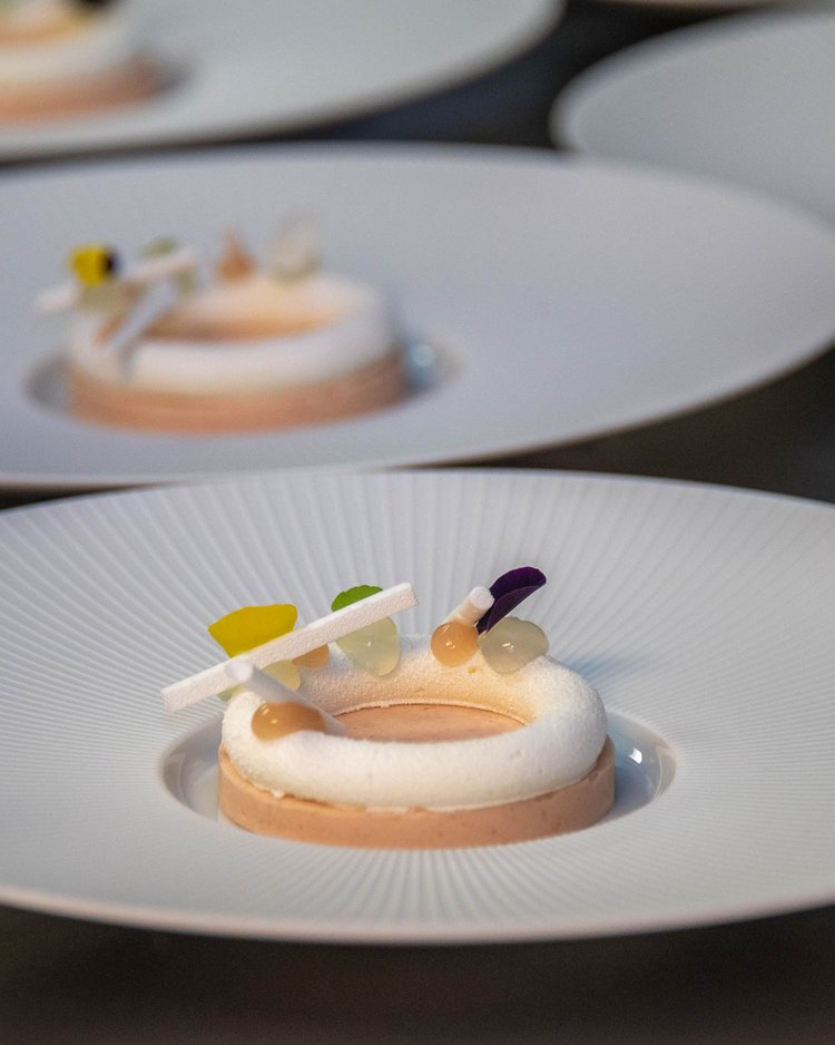 Außergewöhnliche Veranstaltungen im Jagdhof Mehrere kunstvoll dekorierte runde Desserts auf weißen Tellern