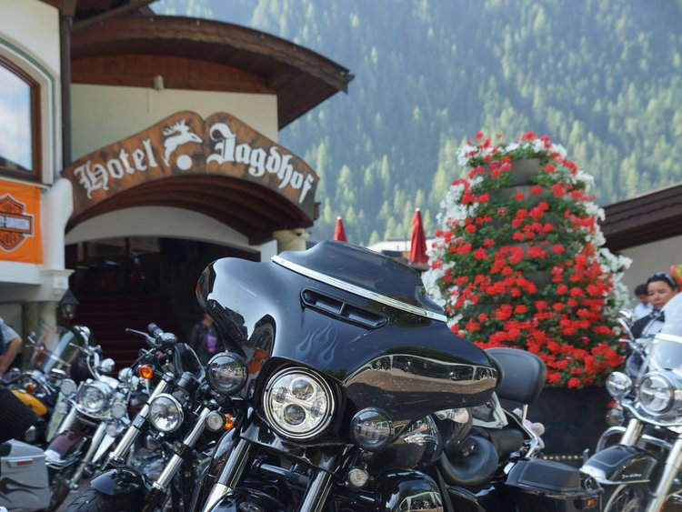 Außergewöhnliche Veranstaltungen im Jagdhof Mehrere Motorräder vor dem Hotel Jagdhof mit Bergen und Blumen im Hintergrund