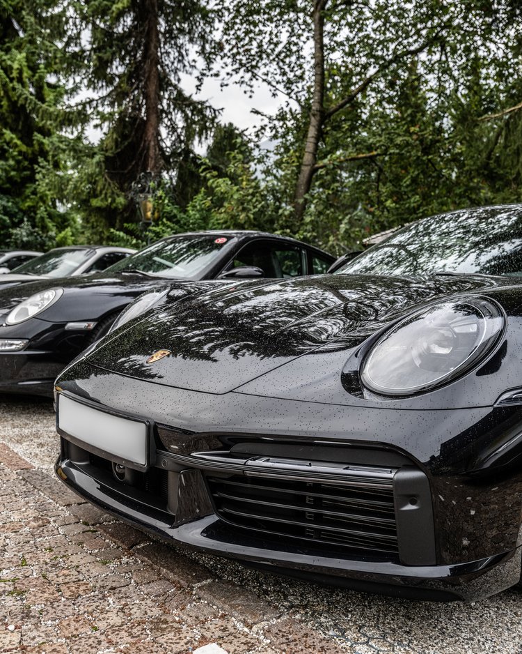 Außergewöhnliche Veranstaltungen im Jagdhof Mehrere geparkte Porsche-Sportwagen neben einem Waldgebiet