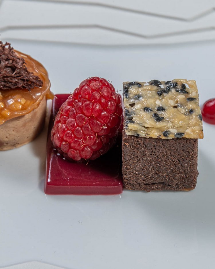 Außergewöhnliche Veranstaltungen im Jagdhof Feines Dessert mit Schokolade, Himbeeren und Fruchtsauce auf weißem Teller