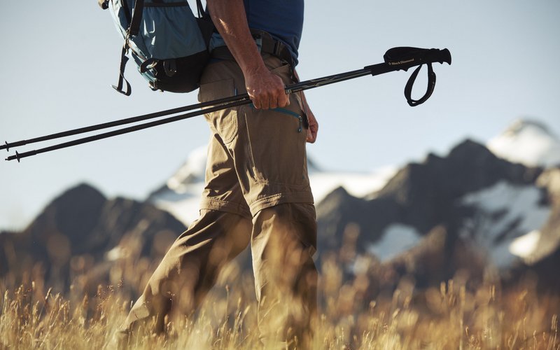 Wie es sich für ein 5-Sterne-Hotel gehört: die Angebote. Wanderer mit Trekkingstöcken und Rucksack vor Berglandschaft