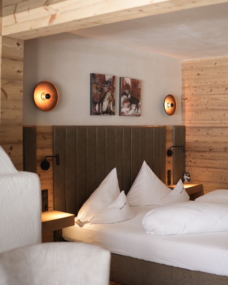 Außergewöhnliche Veranstaltungen im Jagdhof Gemütliches Schlafzimmer mit Holzwänden und Doppelbett