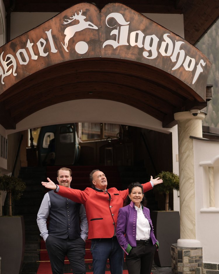 Außergewöhnliche Veranstaltungen im Jagdhof Drei Personen stehen vor dem Eingang des Hotels Jagdhof mit rotem Teppich