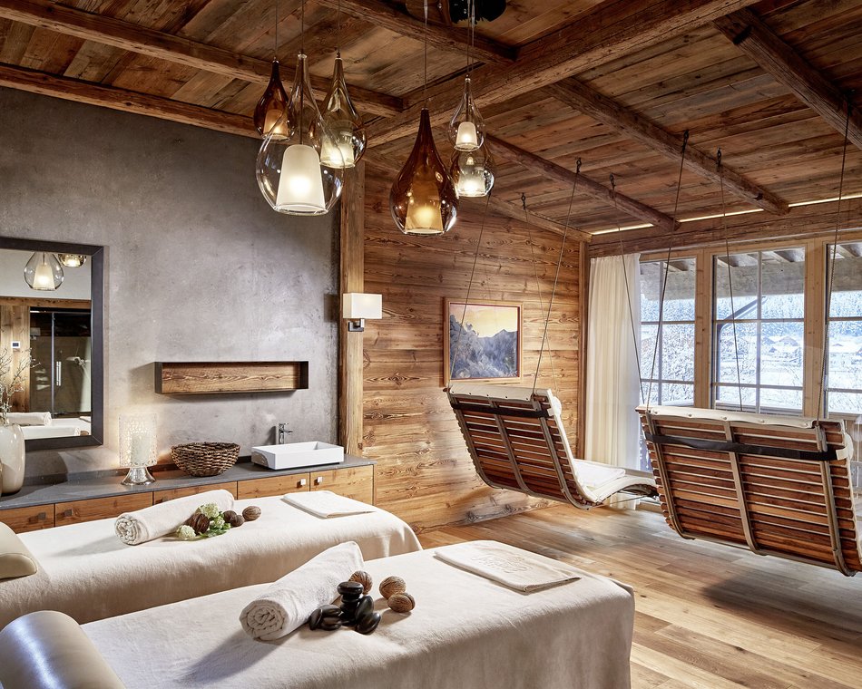 Willkommen im einzigen 5-Sterne-Hotel im Stubaital! Gemütlicher Spa-Raum mit Massageliegen und Holzschaukeln vor Panoramafenster