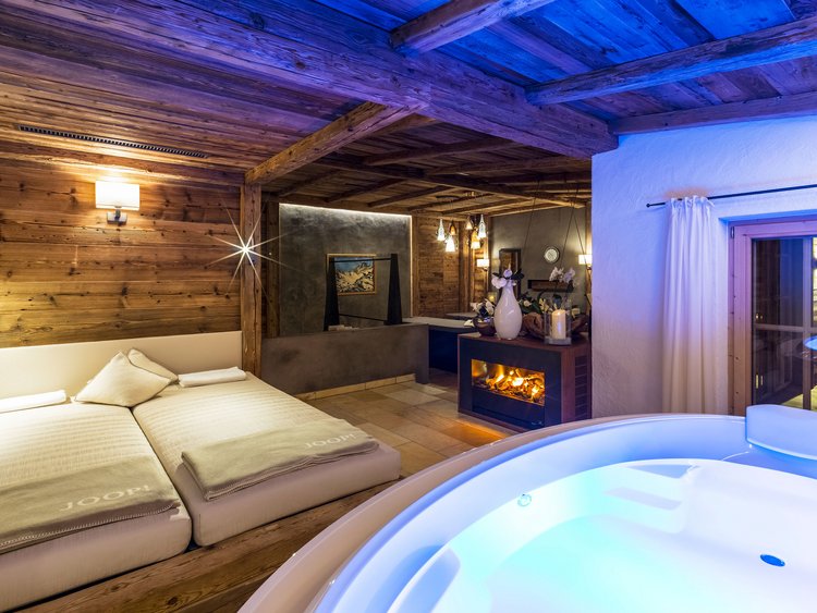 La suite con spa in camera più bella dell’Austria Camera accogliente con vasca idromassaggio, camino e letto matrimoniale in ambiente in legno
