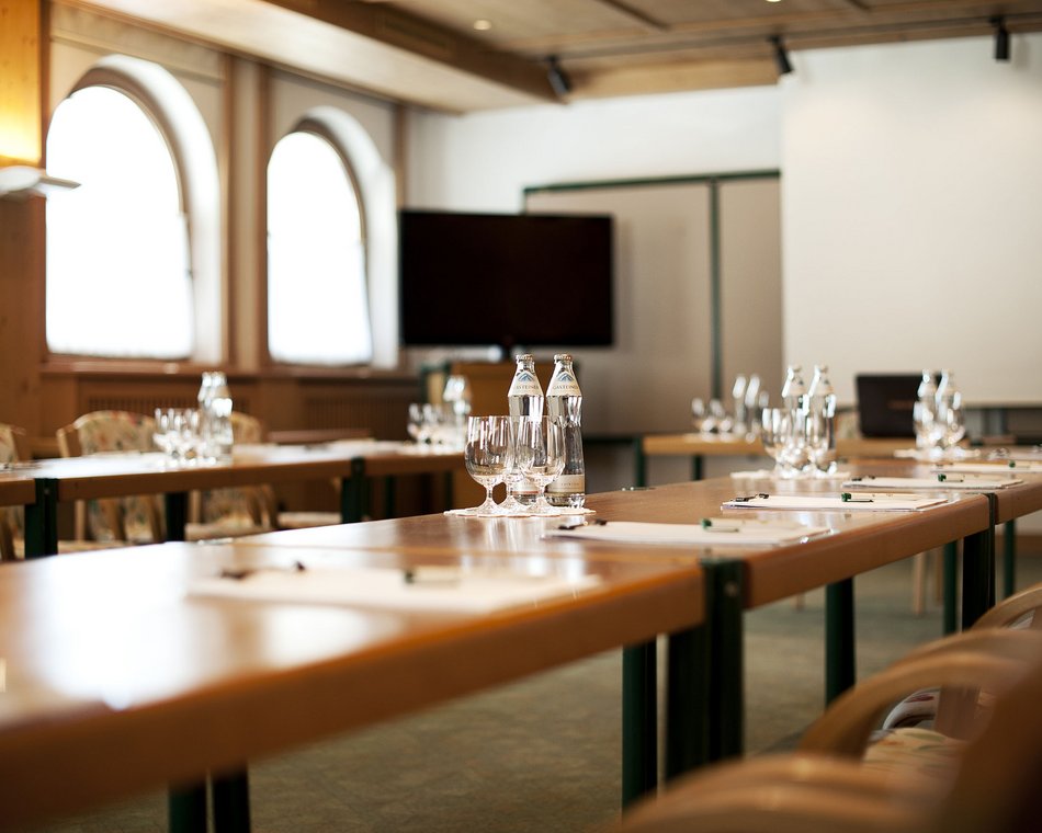 Willkommen im einzigen 5-Sterne-Hotel im Stubaital! Konferenzraum mit Tischen, Stühlen, Wasserflaschen und Gläsern