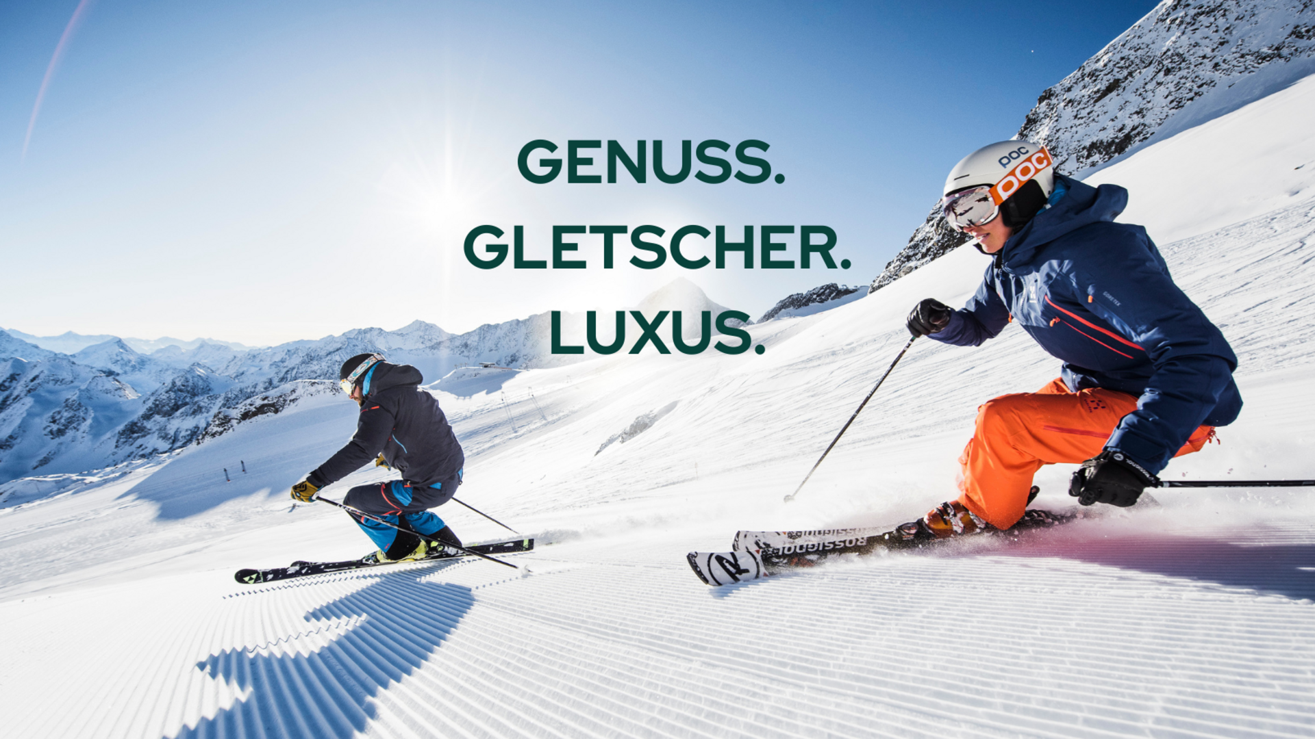 Willkommen im einzigen 5-Sterne-Hotel im Stubaital! Zwei Skifahrer fahren auf präparierter Piste bei sonnigem Wetter auf einem Gletscher