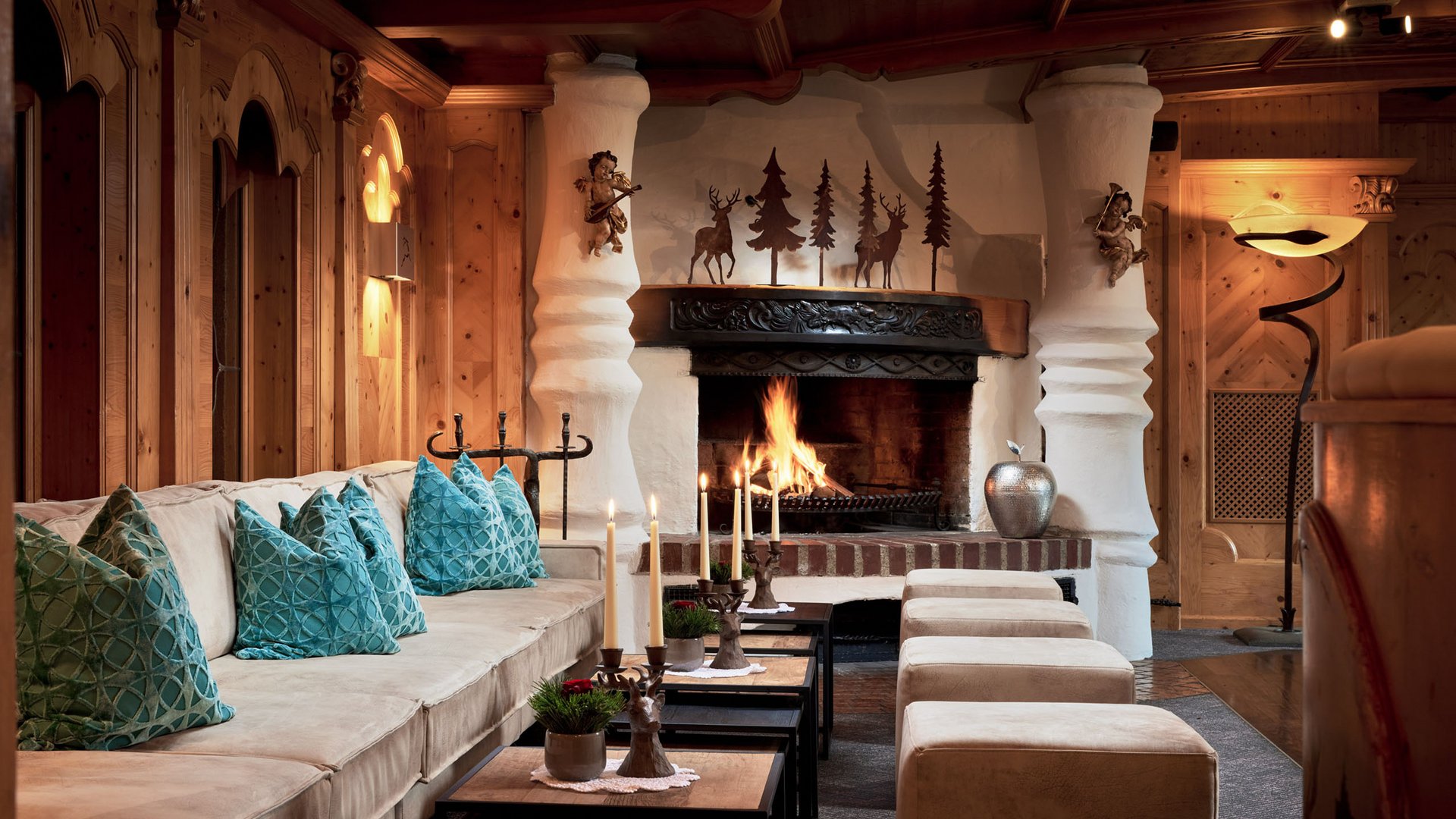 Willkommen im einzigen 5-Sterne-Hotel im Stubaital! Gemütlicher Wohnzimmerbereich mit Kamin, Kerzen und blauen Kissen