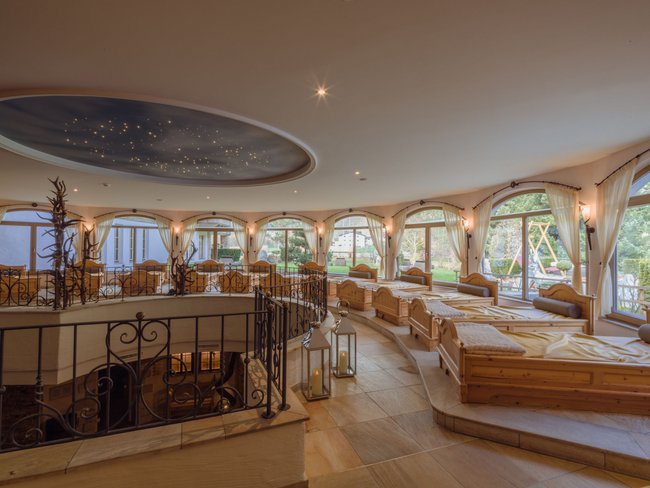Auf in Ihr De-luxe-Wellnesshotel im Stubaital Ruheraum mit Holzbänken, großen Fenstern und Sternenhimmel-Decke