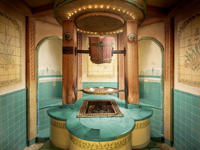 Auf in Ihr De-luxe-Wellnesshotel im Stubaital Traditioneller Kräutersalzraum mit grünem Mosaik und hängendem Holzeimer