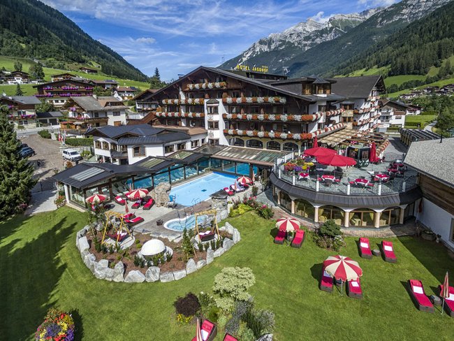 Willkommen im einzigen 5-Sterne-Hotel im Stubaital! Hotel mit Garten, Pool und Liegestühlen in den Bergen bei Sonnenschein