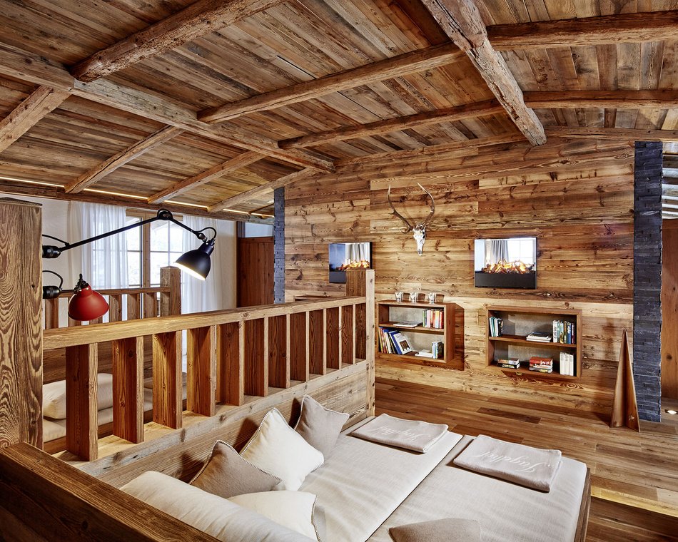 Willkommen im einzigen 5-Sterne-Hotel im Stubaital! Gemütlicher Holzinnenraum mit Kamin, Sofa und Bücherregal