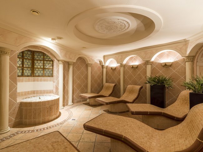 Auf in Ihr De-luxe-Wellnesshotel im Stubaital Eleganter Wellnessraum mit Liegen und antiker Deckenverzierung