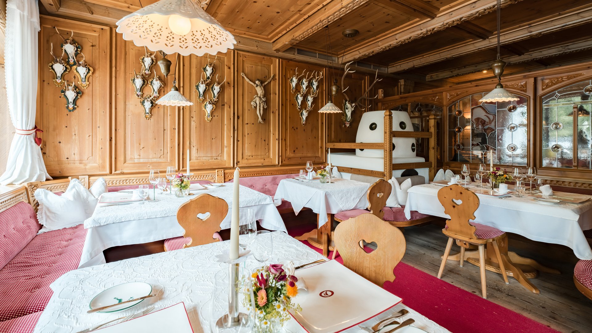 Eines der besten Haubenrestaurants in Tirol Rustikales Restaurant mit Holzvertäfelung und Hirschgeweihen an der Wand
