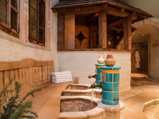 Auf in Ihr De-luxe-Wellnesshotel im Stubaital Traditioneller Fußbadbereich mit Holzbank und gefliesten Becken