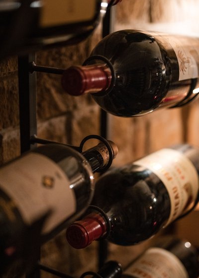 Eines der besten Haubenrestaurants in Tirol Weinflaschen in einem Weinregal an einer Steinwand