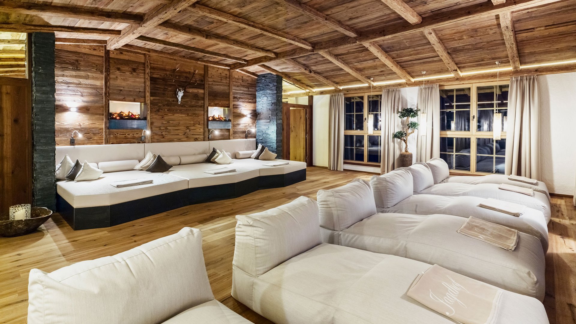 Willkommen im einzigen 5-Sterne-Hotel im Stubaital! Gemütlicher Ruheraum mit großen weißen Liegen und Holzdecke