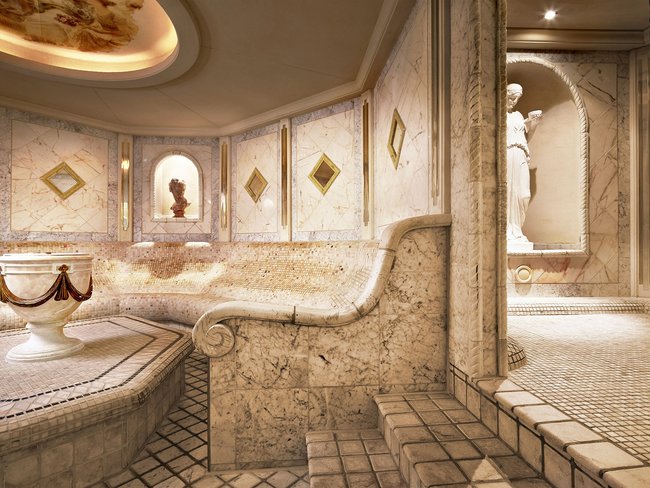 Auf in Ihr De-luxe-Wellnesshotel im Stubaital Luxuriöser Marmorraum mit kunstvollen Statuen und geschwungenen Sitzbänken