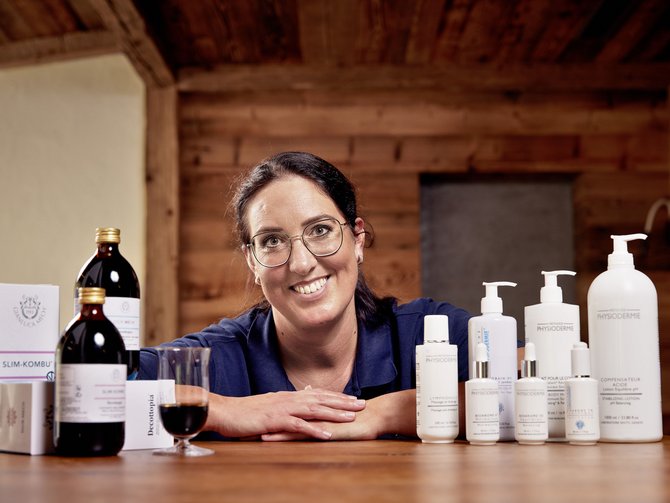Your wellness treatments at the Jagdhof Woman presenting skincare products and drinks on a wooden table
